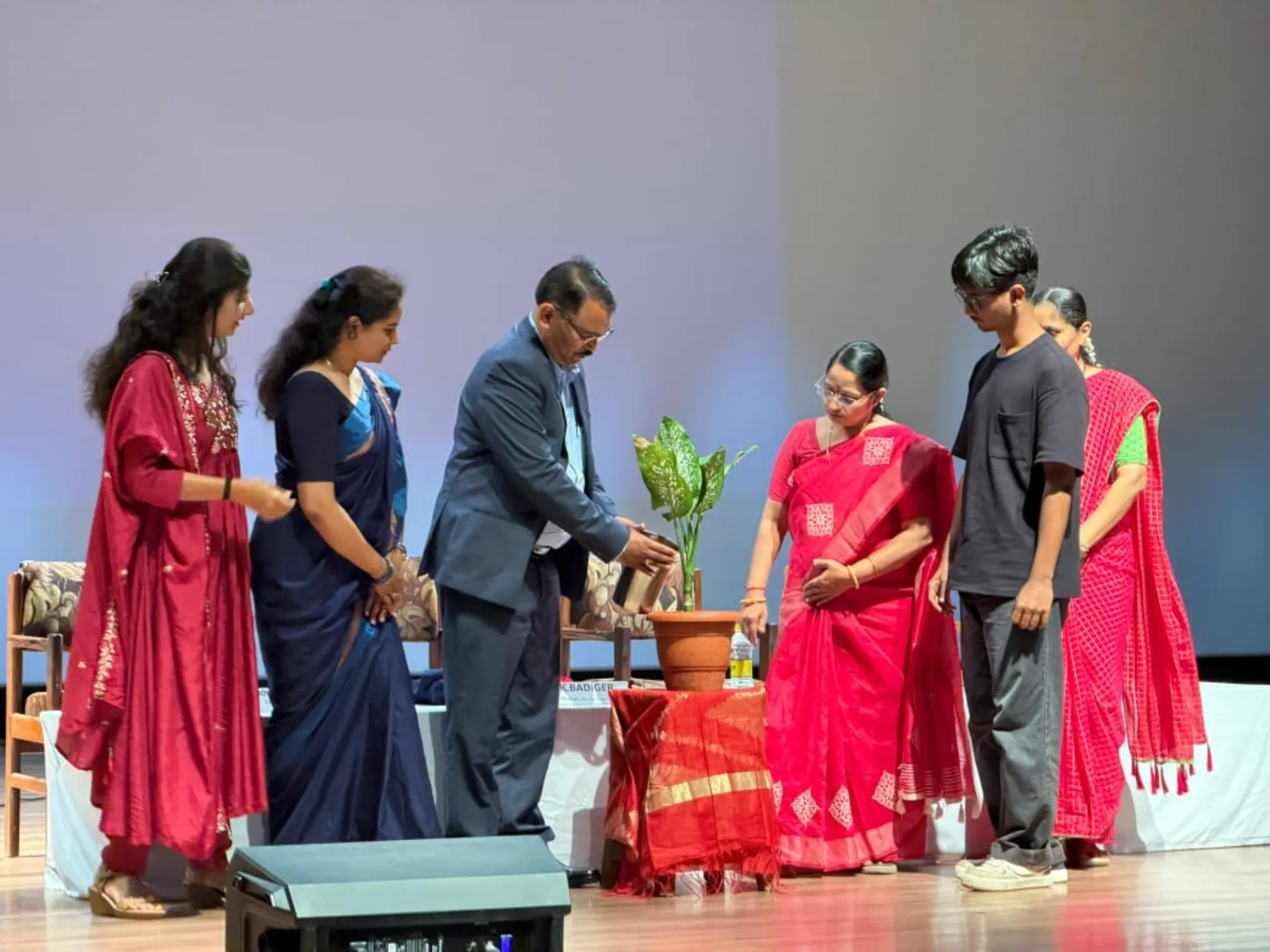 Inauguration by the resource person watering a sapling, with faculty and student representatives