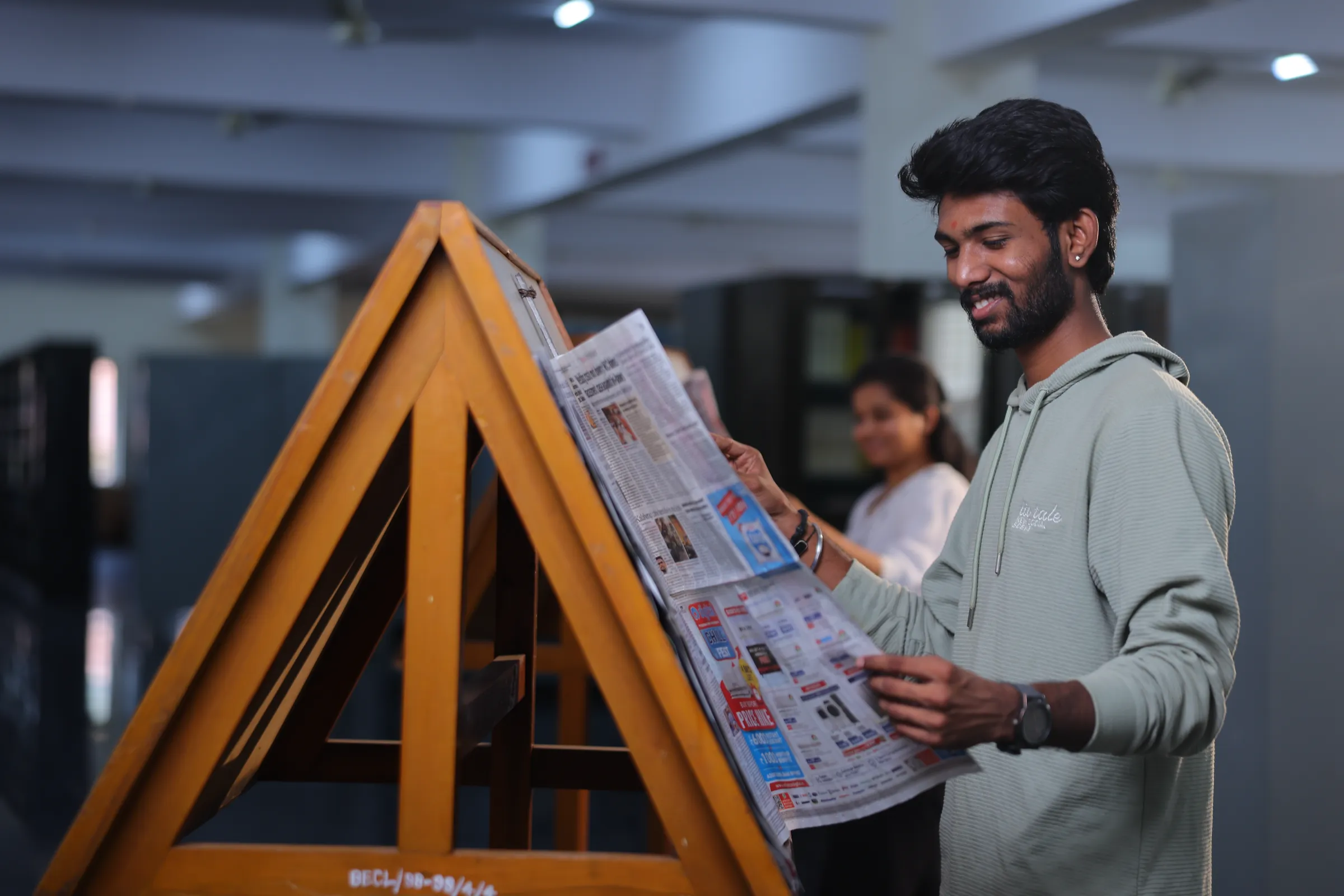 Student browsing newspapers at the periodicals stand