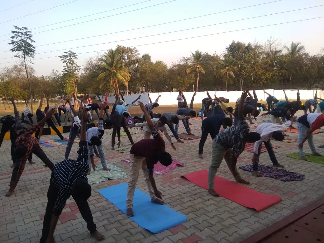 Students perform Surya Namaskar at an outdoor yoga session on campus