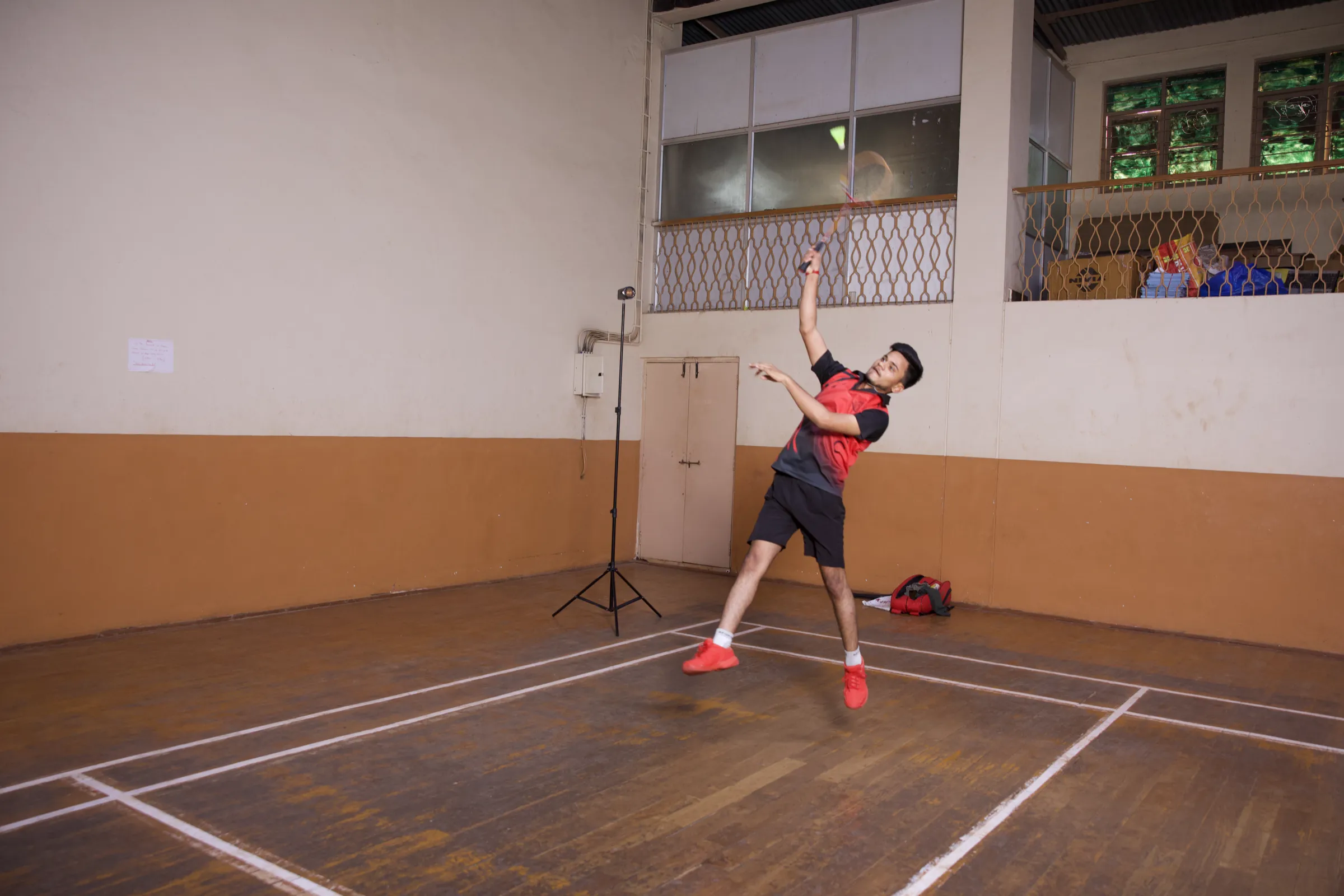 A BEC student executes a jump smash during badminton practice
