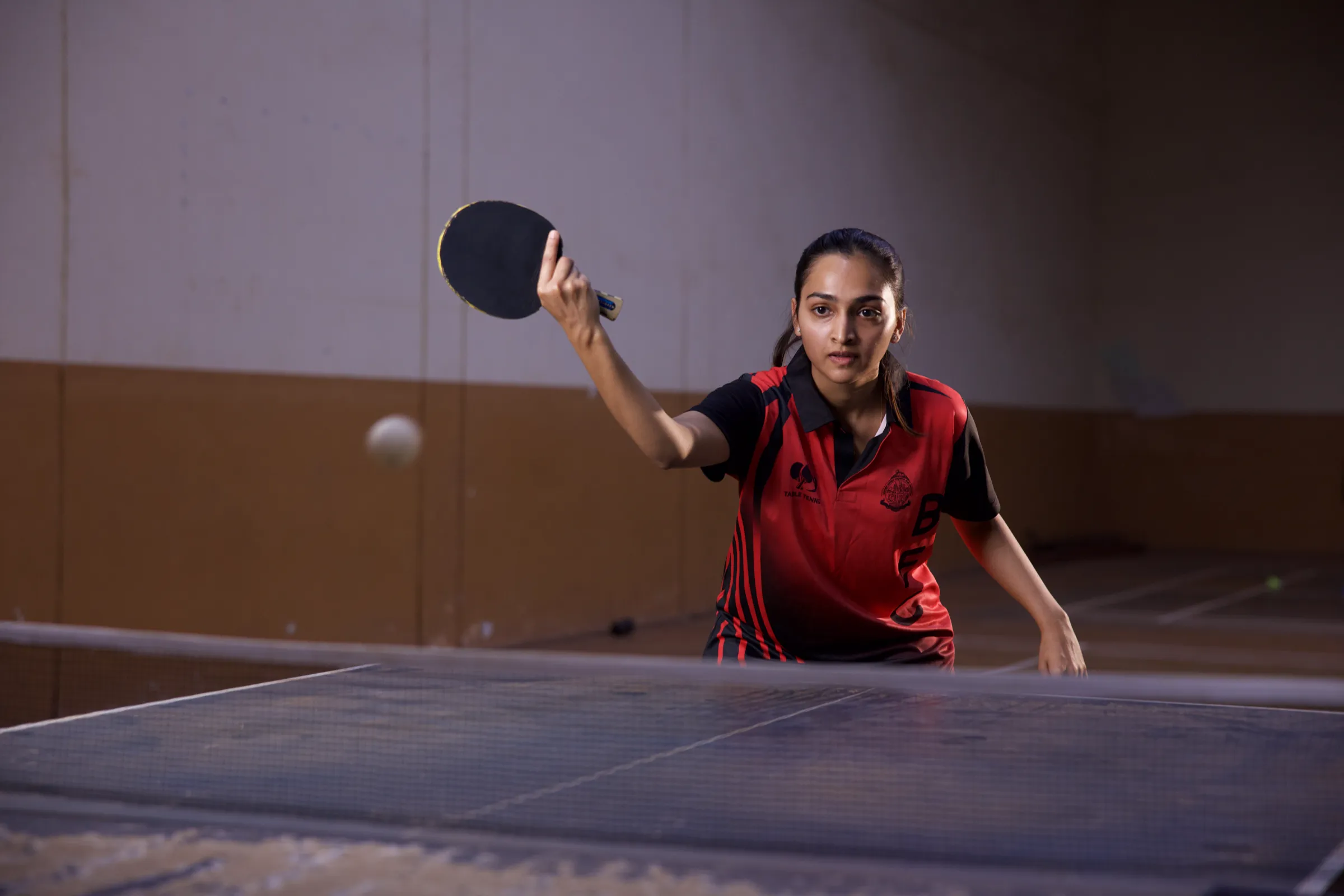 A BEC student plays a forehand return during a table tennis rally