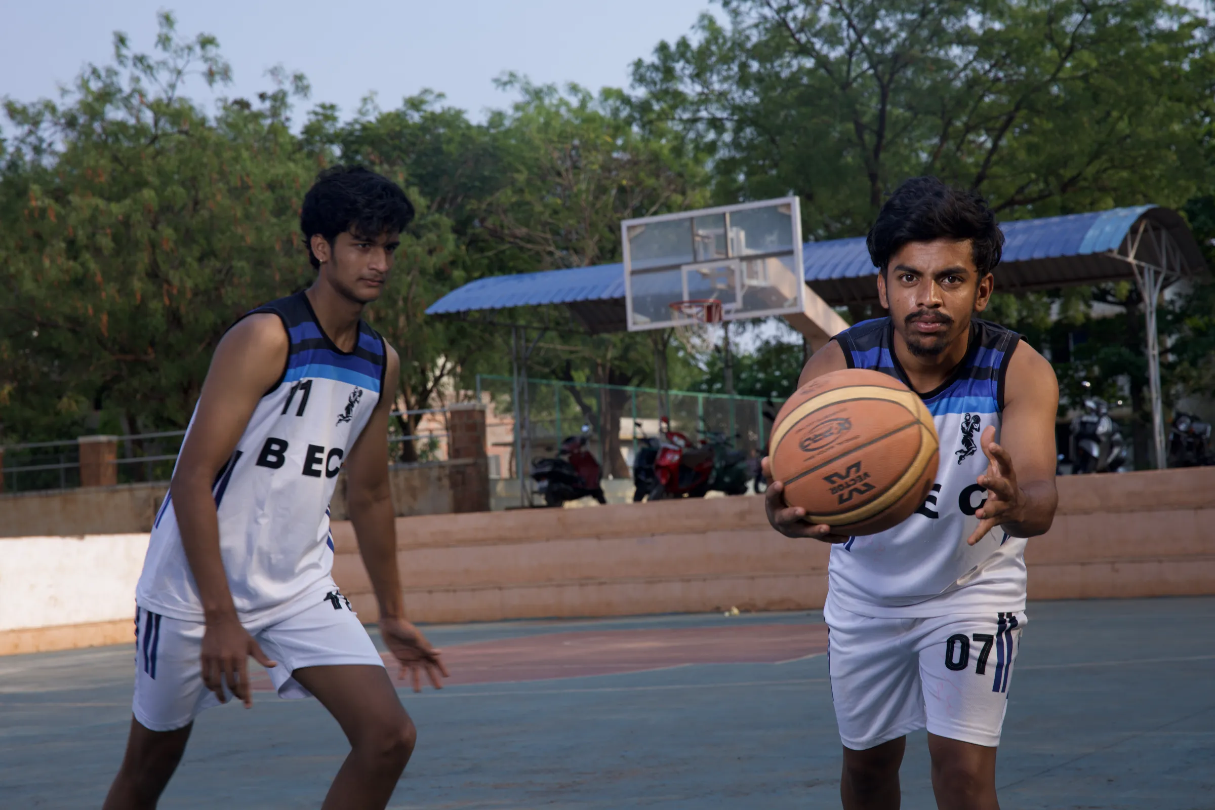 BEC basketball players drive the ball on the outdoor court